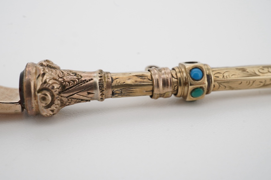 An early 20th century engraved yellow metal, citrine and turquoise set propelling pencil (turquoise stone missing), 42mm, together with a yellow metal whistle charm. Condition poor to fair